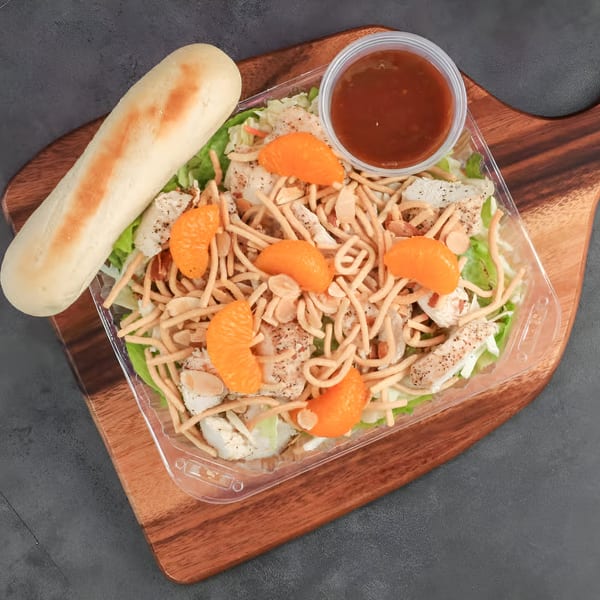Chilly Jilly'z Asian chicken salad with mandarin oranges, crispy noodles, and a breadstick.